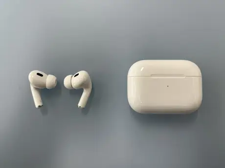 Apple AirPods wireless earbuds resting beside their case