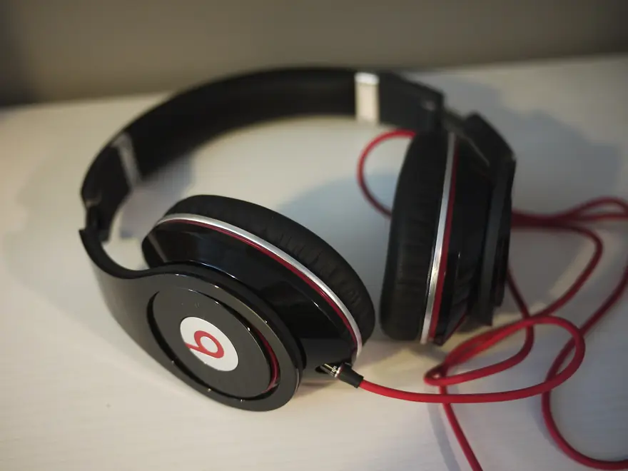 Matte black Beats Studio Pro over ear headphones folded on a dark studio surface