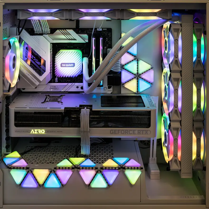 White high-end gaming desktop with rainbow RGB fans, custom cooling, and a GeForce RTX graphics card