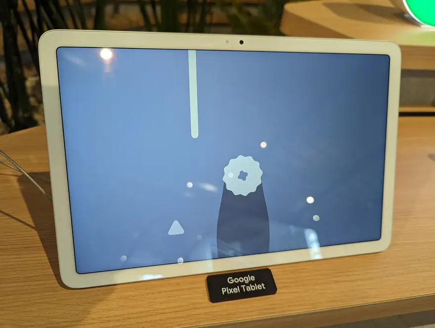 White Google Pixel Tablet standing on a wooden retail display stand with a small name placard