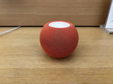 Small round Apple HomePod mini speaker on a countertop