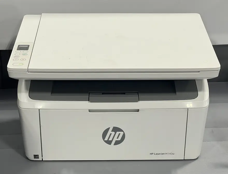 White HP all-in-one inkjet printer with paper tray extended on a desk