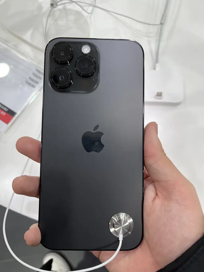 Apple iPhone 14 Pro Max held upright showing its large 6.7 inch display glowing